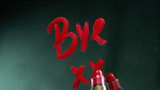 Een vrouw die gaat scheiden en met lippenstift 'Bye' schrijft op de spiegel