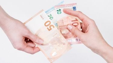 financieel misbruik / twee handen houden briefgeld vast