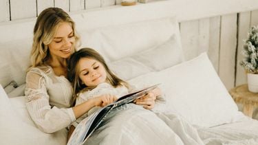 vrouw leest dochtertje voor