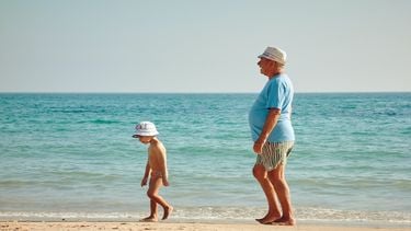 Een opa op het strand met zijn kleinkind: waarom een dagje uit met je schoonfamilie een goed idee is