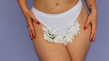 Vrouw met bloemen in haar onderbroek die de geur van haar vagina maskeren