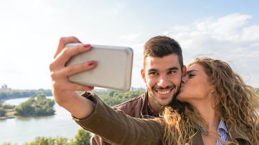foto's / vrouw kust man en maakt selfie