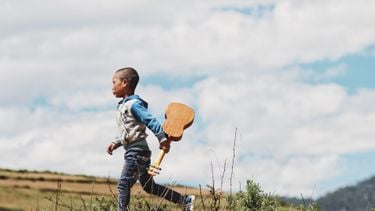 kind rent met een gitaar in zijn hand