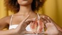 Vrouw die een grapefruit vasthoudt wat symbool staat voor vaginale problememen