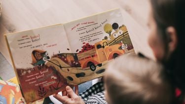 Moeder en kind lezen boekje waarbij ze handige tips toepast