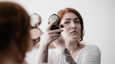 vrouw gebruikt talkpoeder in beauty routine