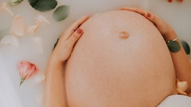 Zwangere vrouw in haar derde trimester die zichzelf een lekker bad gunt
