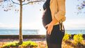 Vrouw die buiten staat en haar zwangere buik laat zien omdat ze HELLP-syndroom heeft
