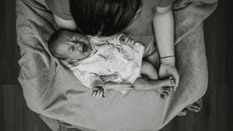 baby huilt na voeding Moeder met huilende baby op haar schoot