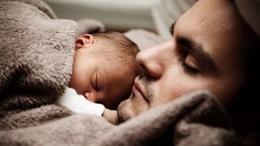 Vader en baby hechten in bed