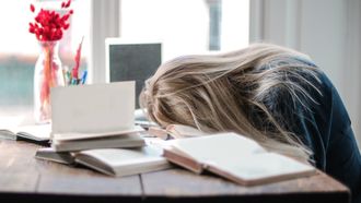 niet geslapen / vrouw ligt met hoofd op de tafel