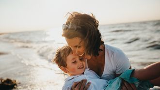 Moeder met haar zoon op het strand en de opvoeding in Nederland doet