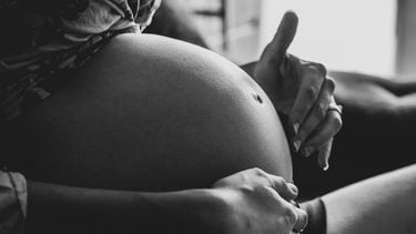 Zwangere vrouw die haar baby in haar buik voelt bewegen