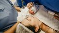 Moeder op de operatietafel die haar baby ontmoet na een keizersnede
