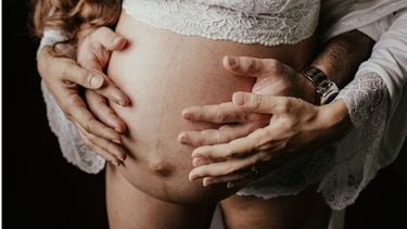 bevalling / zwangere buik met vier handen