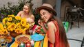 twee vrouwen in kleurrijke jurken eten een gezonde vegan maaltijd