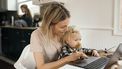 werkende moeder met kind op schoot