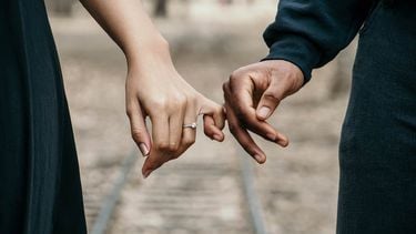 twee mensen houden elkaars hand vast