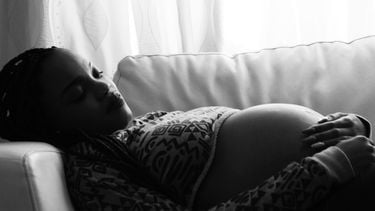Zwangere vrouw die op de bank ligt en heel ontspannen haar bevalling in gaat door hypnobirtingdoo