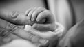 Hand van baby in moederhand na bevalling