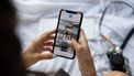vrouw houdt telefoon met apps voor ouders vast