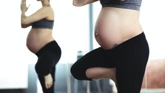 vrouw doet yoga pose en is nu zwanger