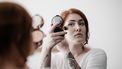 vrouw gebruikt talkpoeder in beauty routine