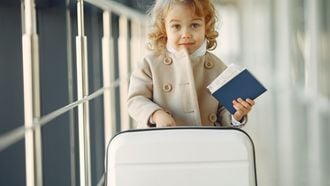 meisje op vliegveld met paspoort verre reis met kind