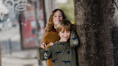 Broer en zus bij een boom wiens relatie nog zal veranderen met de jaren