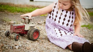 Kind met een rustig temperament dat aan het spelen is met een speelgoedauto
