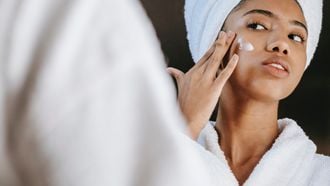 Vrouw die gefermenteerde skincare op haar gezicht smeert