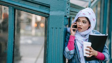 Vrouw die zich niet veilig voelt op straat en doet alsof ze belt om het hoekje