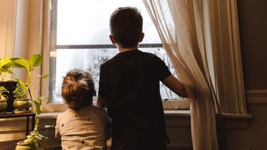 Twee kinderen die naar buiten kijken en niet weten welke binnenactiviteiten ze moeten doen