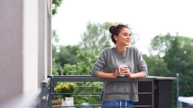 vrouw drinkt koffie buiten als onderdeel van haara ochtendroutine