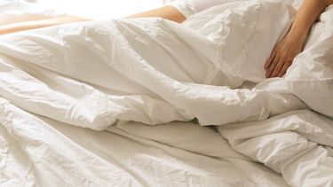 vrouw is naakt aan het slapen in bed