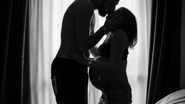 Man die zwangere vrouw kust