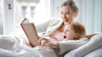 voorlezen / moeder en kind lezen een boek in bed