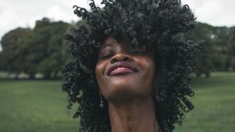 vrouw is blij door het manifesteren van geluk in haar leven