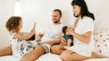 ouderschap apps / familie zit op bed