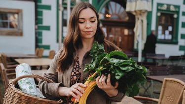 Vrouw die groene groente koopt die bevorderlijk zijn voor de vruchtbaarheid